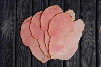 Top view of slices of fresh ham on wooden table