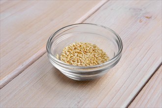 Sesame seeds in a little glass bowl on wooden table