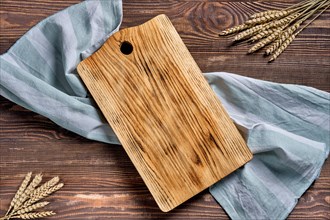Overhead view of wooden cutting board with napkin on a table