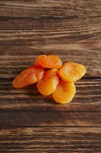 Small heap of dried apricots on wooden table