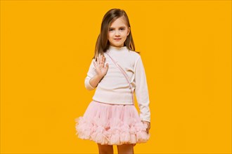 Cute little child posing on bright yellow background