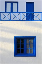 Typical architecture with whitewashed wall and blue windows