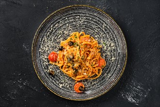Overhead view of pasta with tomato and olives