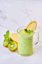 View from above on kiwi and lemon smoothie with mint on marble background