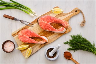 Top view of raw fresh salmon steak on wooden cutting board