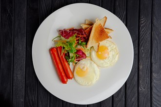 Top view of plate with fried eggs with sausages