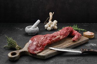 Raw beef tri-tip loin on wooden cutting board