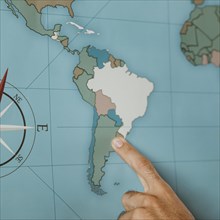 Person pointing south america map
