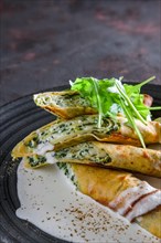 Thin pancakes stuffed with arugula and cheese