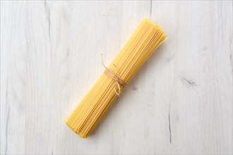 Overhead view of raw spaghetti on wooden table