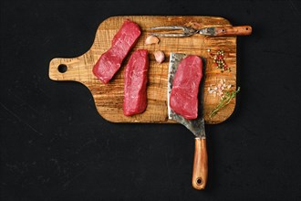 Top view of raw boneless strip steak on black background
