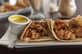 Delicious Mexican chicken tacos with salsa and pico de gallo served on the table
