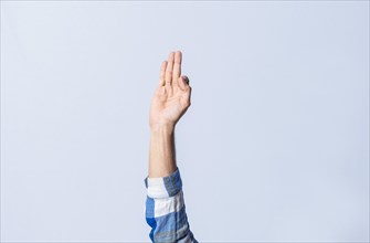 Hand gesturing the letter F in sign language on isolated background. Man hand gesturing the letter F of the alphabet isolated. Letters of the alphabet in sign language