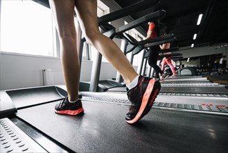 Woman wearing sneakers using treadmill. Resolution and high quality beautiful photo