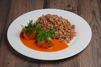 Buckwheat porridge and meatballs on wooden table