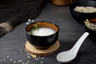 Rice soup black bowl wooden support white spoon
