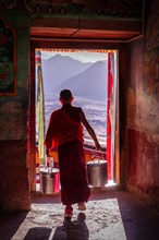 A young monk going through a door at Thiksey Monastery