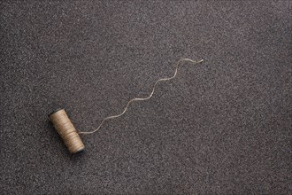 Top view of untwisted linen twine on dark stone background