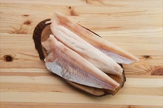Top view of frozen fillet of pangasius on wooden table