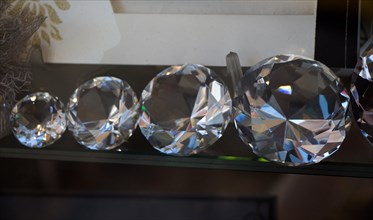 Five transparent diamonds aligned from small to big on display