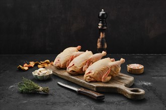 Three little raw chicken on wooden cutting board