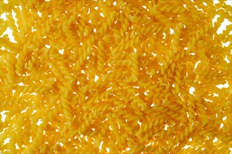 Top view of fusilli pasta scattered on white