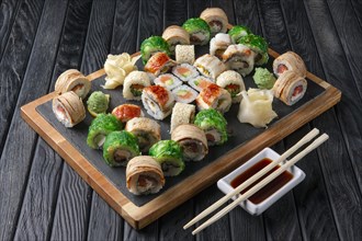 Big set of rolls served on stone plate. Layout for menu