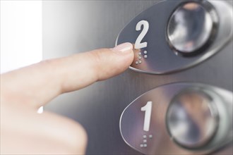 Hand touching elevator braille figure
