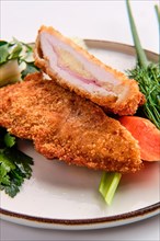 Close up view of baked cutlet stuffed with ham and cheese