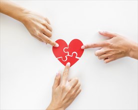 Top view hands touching puzzle heart pieces. Resolution and high quality beautiful photo