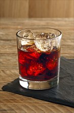 Rum and cola cocktail on wooden background
