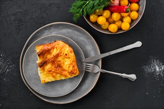 Cheese puff pie from unleavened dough on black wooden background