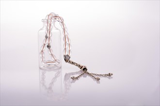 Prayer beads and bottle on a white background