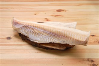 Frozen fillet of cod on wooden table