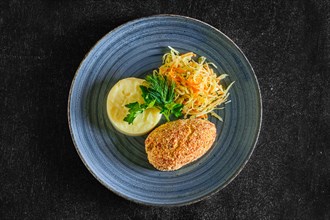Top view of Kiev cutlet with mashed potato and pickled cabbage