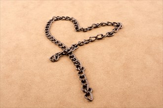 Chain form a heart shape on a brown background