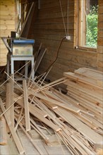 Joinery with electrick saw and pile of planks scattered on the floor