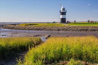 Tidal creek with lighthouse Kleiner Preusse on the Wadden Sea at the mouth of the Weser