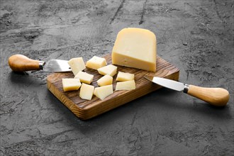 Goat cheese cut on pieces on wooden cutting board