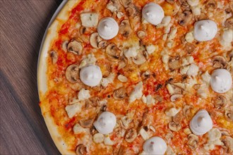 Top view of pizza with mushrooms and mayonnaise sauce cutted on pieces