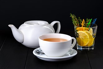 Ceramic tea pot and cup with echinocea tea on dark background