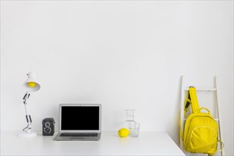 Stylish workplace white yellow colors with backpack laptop. Resolution and high quality beautiful photo