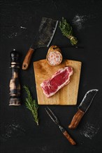 Top view of raw strip steak boneless on dark background
