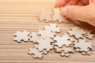 Man holding last piece of jigsaw puzzle as business strategy concept