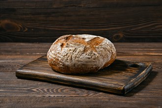 Artisan whole grain tomato wheat bread on wooden board