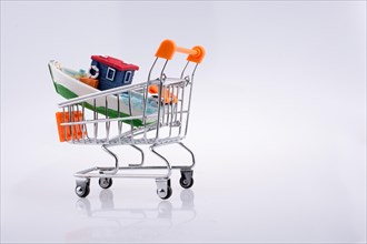 Little colorful model boat in shopping cart on white background