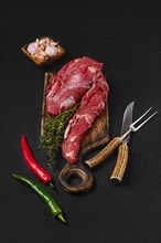 Raw beef whole tenderloin for steak fillet mignon on black background