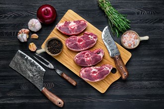 Overhead view of chopped fresh lamb shank with spice on cutting board with spice