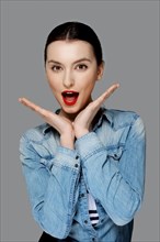Happy fashion model in jeans shirt with tan makeup and red mat lips with open mouth