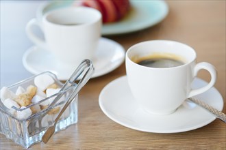 Cup of hot coffee and croissant on background in cafe photo with shallow depth of field